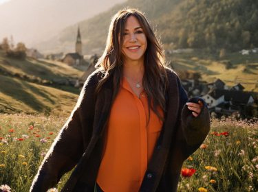 Simone Thomalla posiert für die Kamera auf einer Wiese.