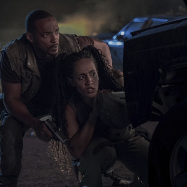 Anthony Mackie und Tiana Okoye hocken in einer 