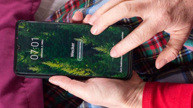 Hand schaltet Wecker auf dem Android-Handy aus.