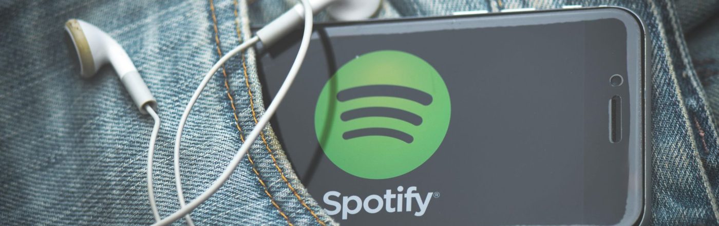 Ein Smartphone mit Spotify steckt in der Hosentasche einer Jeans.