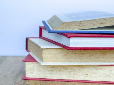 Die Nahaufnahme eines Bücherstapels auf einem Tisch.