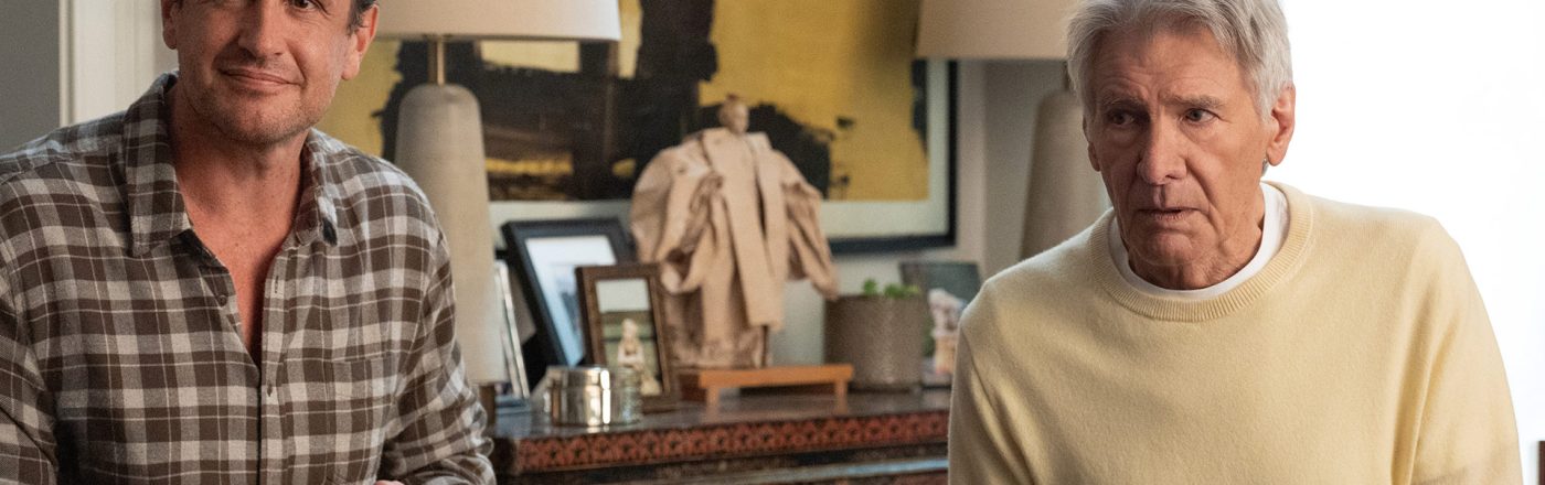 In dieser Szene aus Shrinking Staffel 3 sitzen Jason Segel und Harrison Ford nebeneinander an einem Tisch und arbeiten an einem Puzzle.