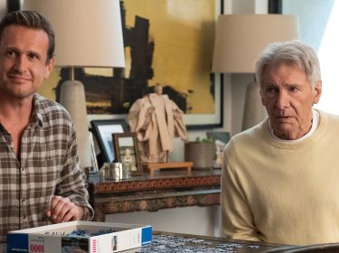 In dieser Szene aus Shrinking Staffel 3 sitzen Jason Segel und Harrison Ford nebeneinander an einem Tisch und arbeiten an einem Puzzle.