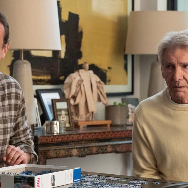 In dieser Szene aus Shrinking Staffel 3 sitzen Jason Segel und Harrison Ford nebeneinander an einem Tisch und arbeiten an einem Puzzle.