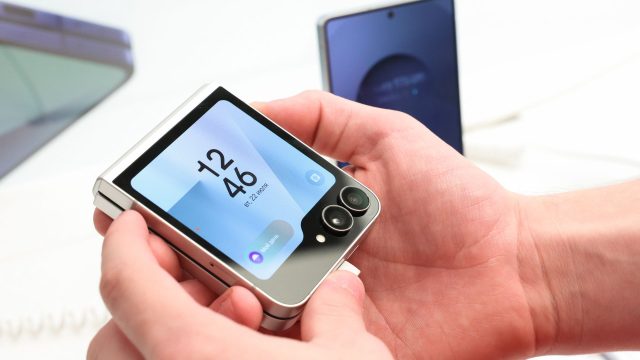 Eine Person hält das zugeklappte Galaxy Z Flip7 hoch.