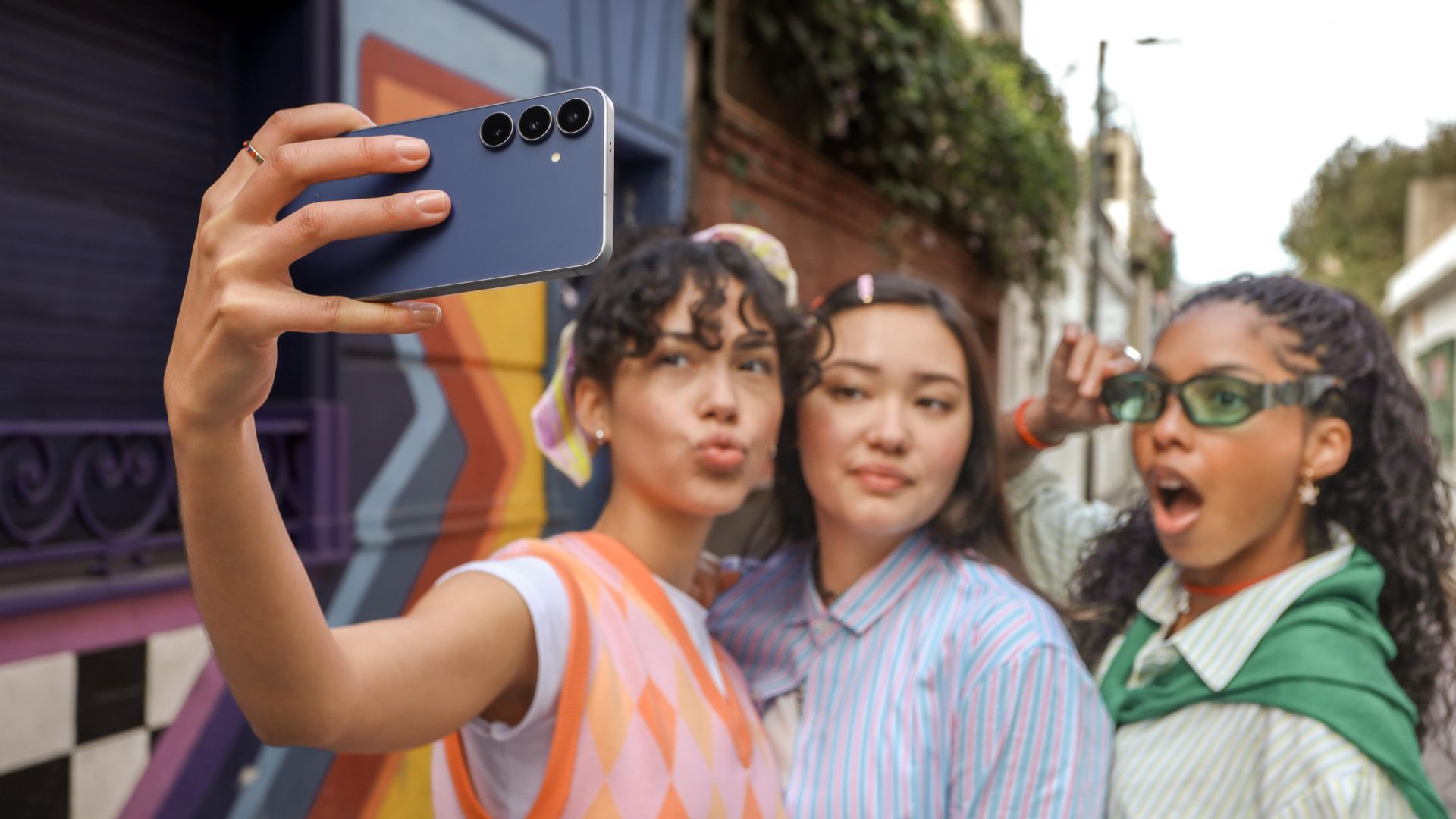 Drei Mädels machen mit dem Handy Galaxy S25 FE ein Gruppenselfie.