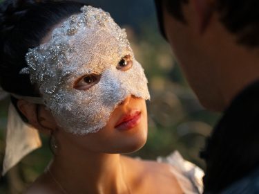 In den Streaming-Highlights im Januar 2026 ist eine Szene aus „Bridgerton“ Staffel 4 abgebildet. Yerin Ha als Sophie Baek in einer romantischen Szene. Sie trägt eine elegante, mit Perlen bestickte weiße Maske und blickt liebevoll in die Augen eines Mannes.