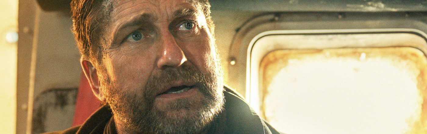 Gerard Butler in Greenland 2: Ein Mann blickt verzweifelt in einer Fahrzeugkabine bei grellem Licht.