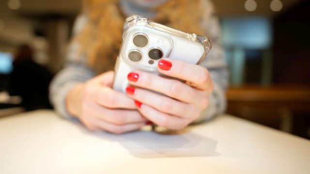 Zwei Hände halten ein iPhone.