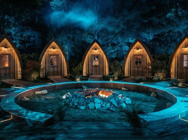 Auf dem Bild in dem Artikel zu „Werwölfe“ Staffel 2 ist ein nächtliches Set mit fünf kleinen, beleuchteten Holzhütten zu sehen.