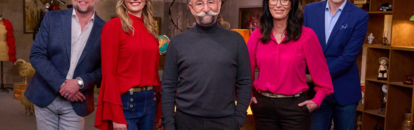 Auf dem Bild mit den Bares für Rares-Expert:innen stehen fünf bekannte Gesichter der Sendung lächelnd nebeneinander im Studio. Von links nach rechts sind Patrick Lessmann, Bianca Berding in roter Bluse, Moderator Horst Lichter mit markantem Schnurrbart, Heide Rezepa-Zabel in pinker Bluse und Detlev Kümmel im blauen Sakko zu sehen. Die Stimmung wirkt freundlich und professionell.