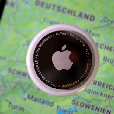 Ein AirTag liegt auf einem iPhone, das einen Landkartenausschnitt von Deutschland und einigen umliegenden Ländern zeigt.
