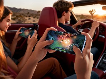 Auf der Rückbank eines Cabrios spielen zwei junge Frauen mit ihren Smartphones