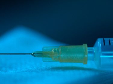 Eine Spritze liegt auf einem Tuch.