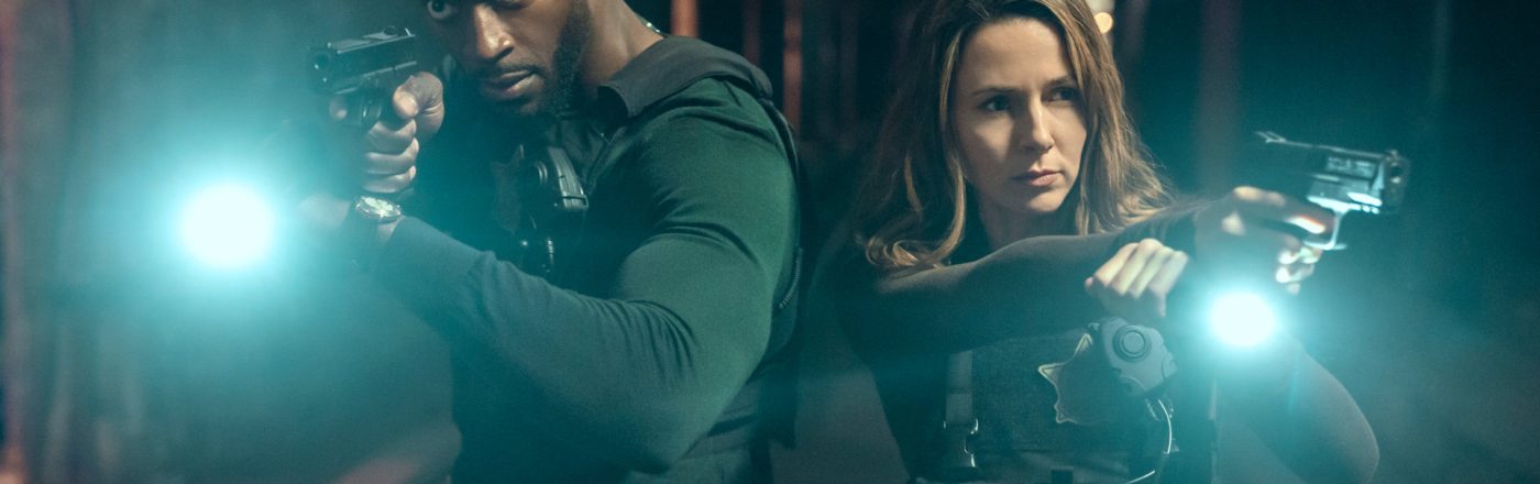 Aldis Hodge als Detective Alex Cross und Alona Tal als Special Agent Kayla Craig. Beide stehen mit gezogener Pistole und einer Taschenlampe im Dunkeln.