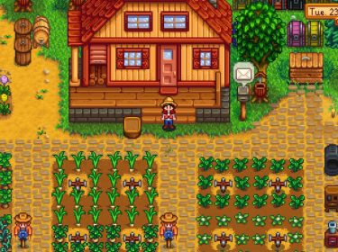 Auf dem Bild aus dem Videospiel Stardew Valley ist der Spieler-Charakter mit Strohhut, rotem Hemd und blauer Latzhose vor einem gemütlichen Farmhaus mit rotem Dach zu sehen. Gepflegte Felder mit Mais und grünen Pflanzen umgeben das Haus, während Maschinen und Kisten rechts platziert sind.