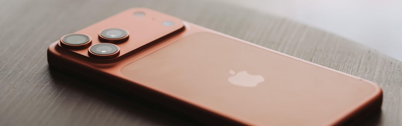 iPhone 17 Pro Max in Orange liegt auf einem Holztisch.