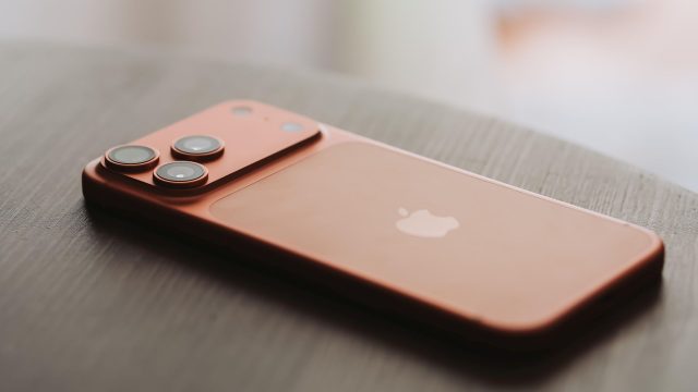 iPhone 17 Pro Max in Orange liegt auf einem Holztisch.