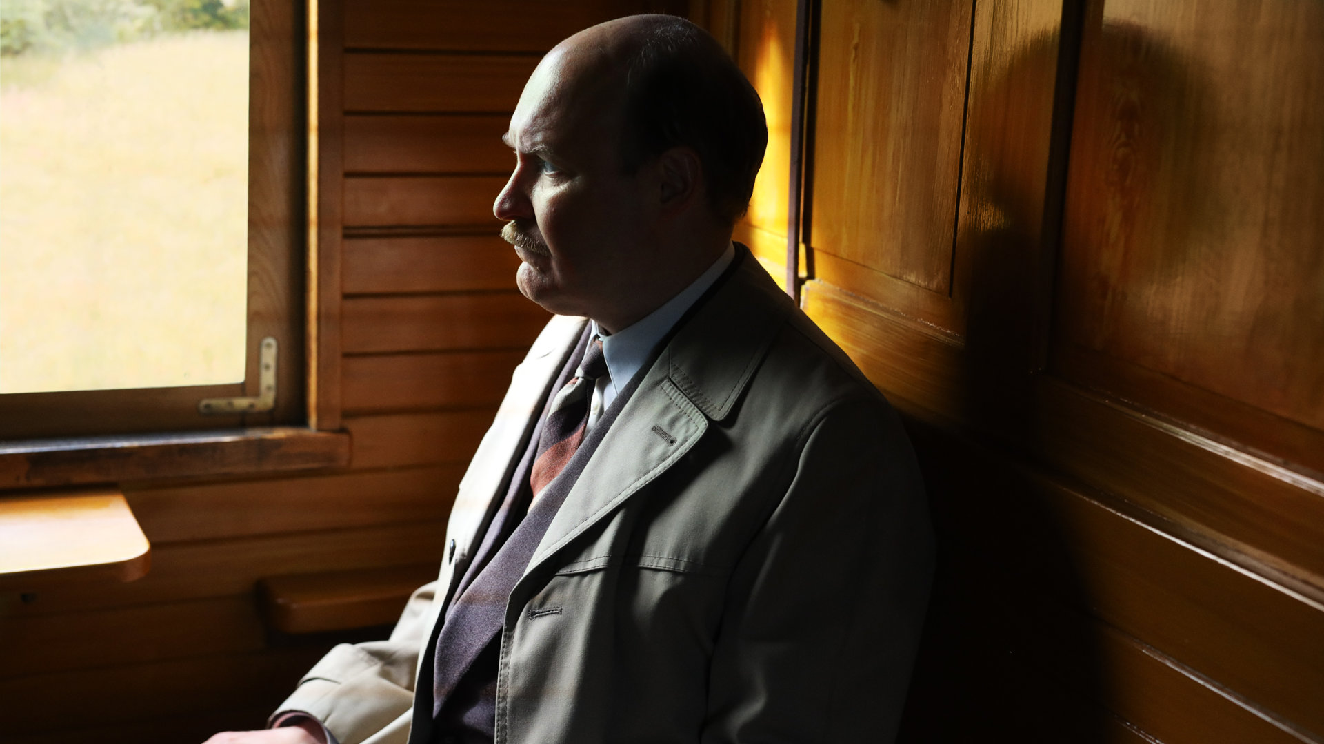 Henrik Dorsin in Die Schwedische Verbindung Ein Mann mit Schnurrbart und fliehender Stirn hält einen Telefonhörer am Ohr.