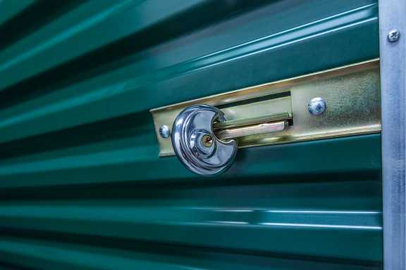 A green self storage door with an lock on it