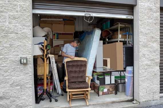 A man standing in his storage for furniture