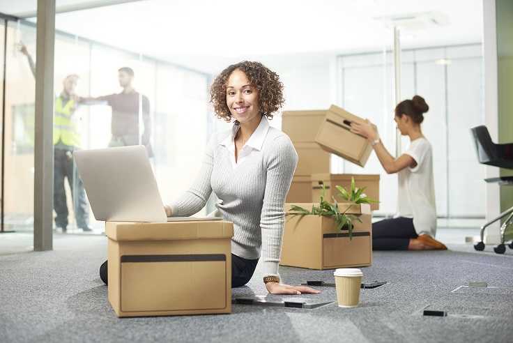 A woman sitting in front of a cardboard box