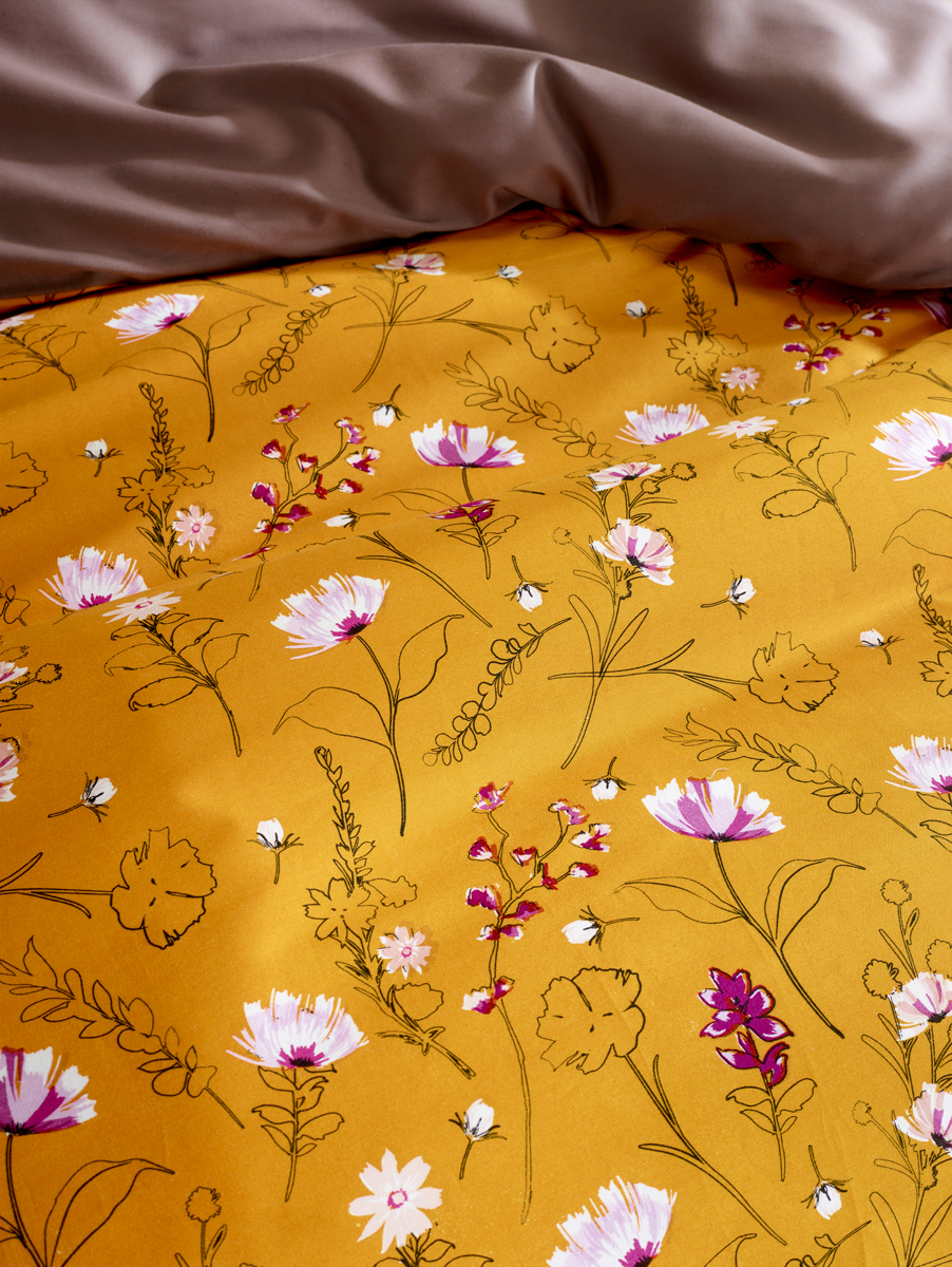 Chique okergouden dekbed dessin met prachtige voorjaarsbloemen.