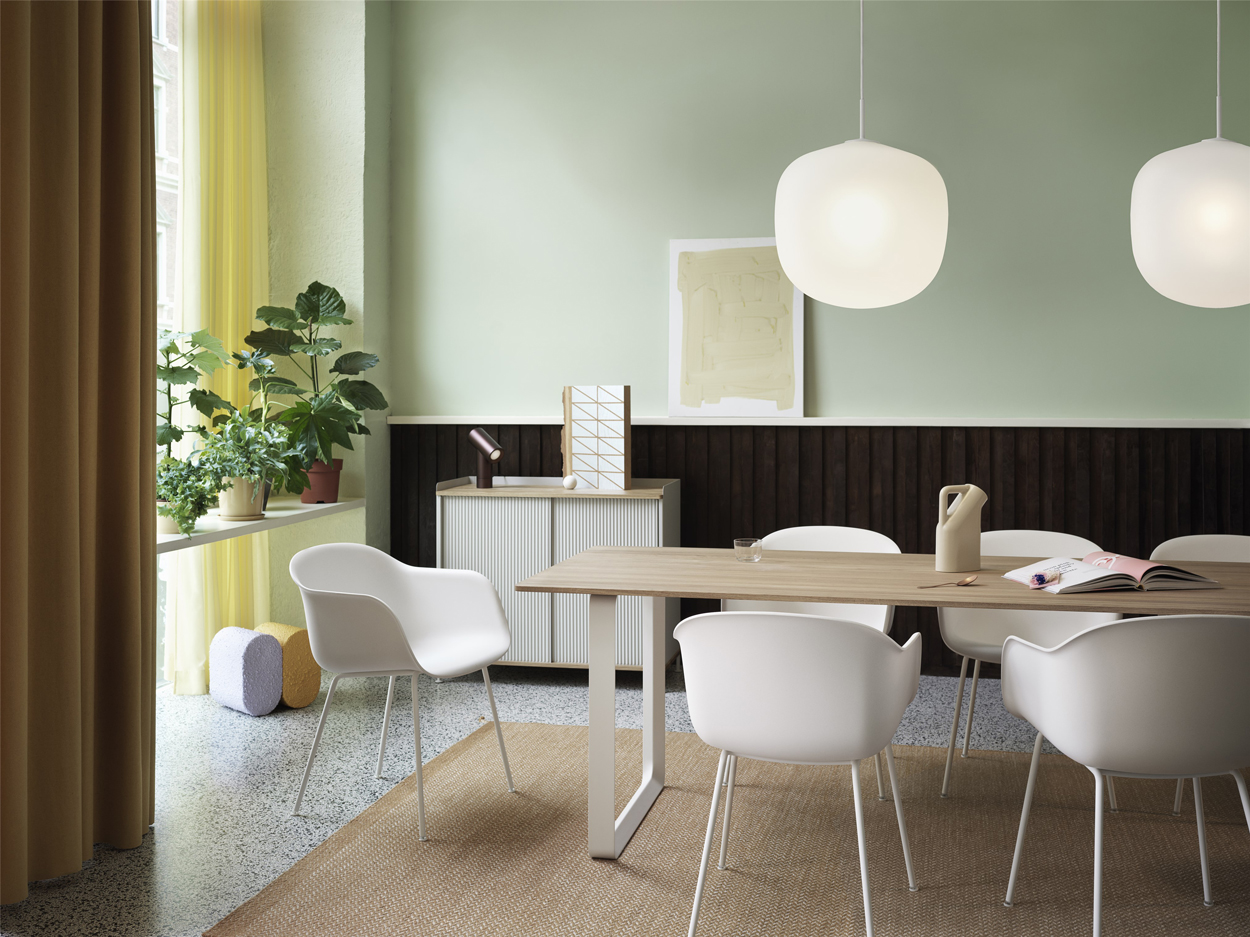 De Muuto 70/70 tafel met wit stalen poten en eikenhouten tafelblad. Ook de witte kuipstoelen zijn van het merk Muuto.