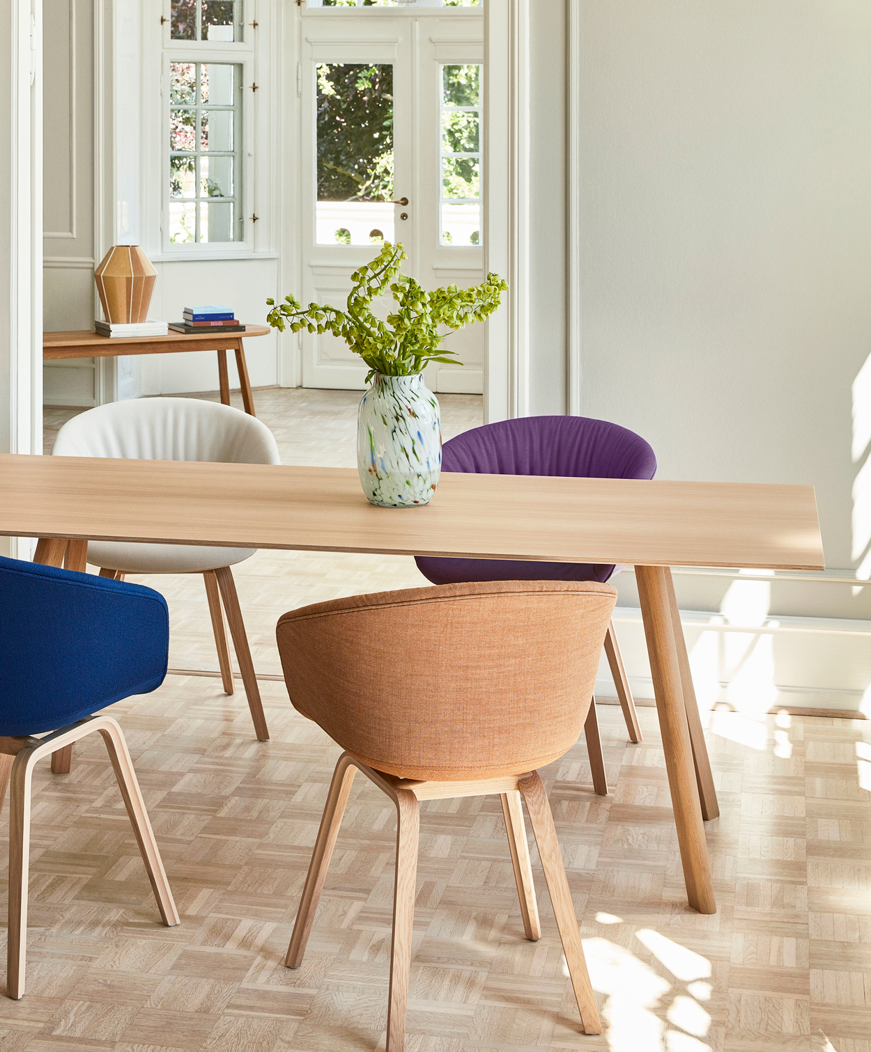 Ruime HAY AAC 34 gestoffeerde eetkamerstoelen met een eikenhouten onderstel. Ook de de HAY CPH 30 tafel heeft een eigenhouten basis.