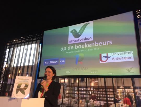 Katelijne stelt de lesmap van Straatvinken voor op de Boekenbeurs.